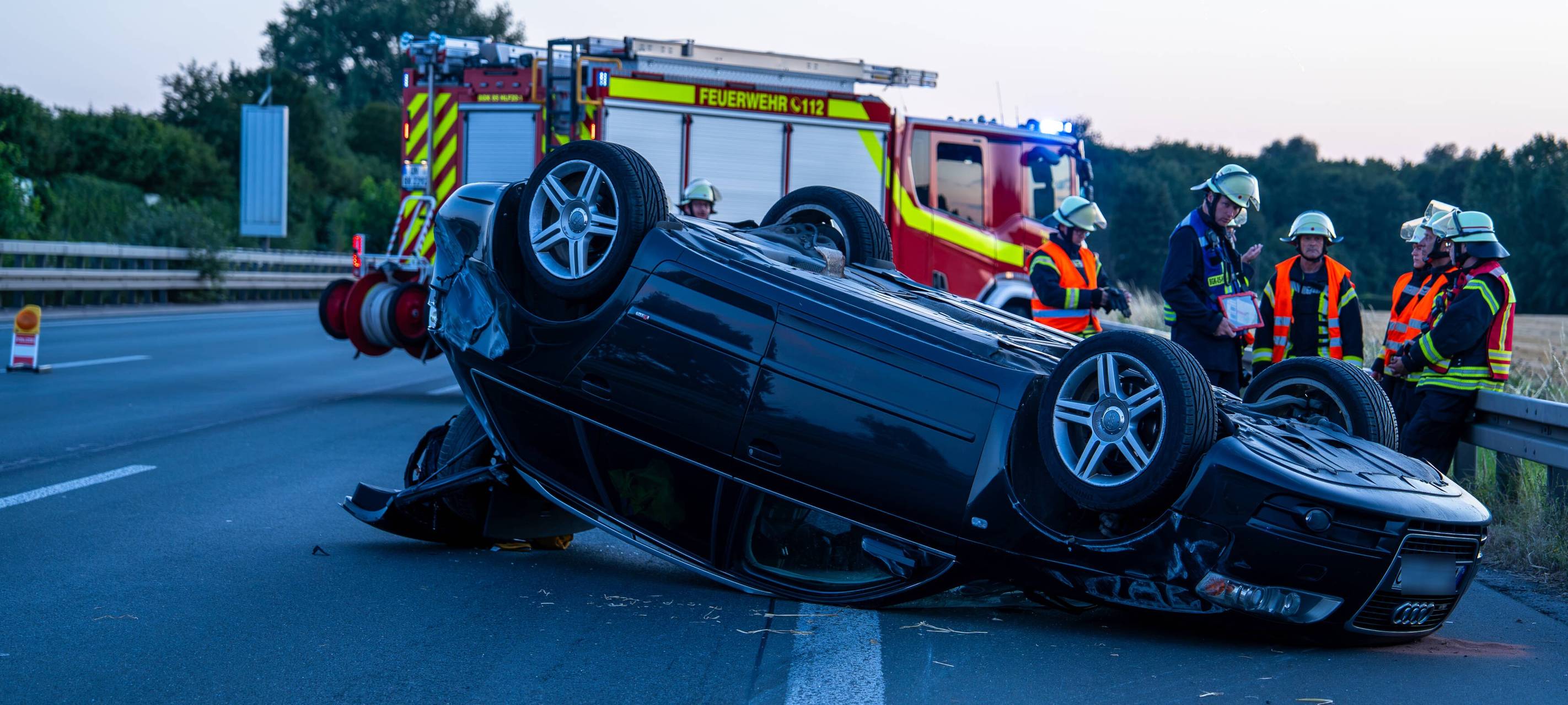 Ein Auto liegt auf der Autobahn nach einem Unfall auf dem Dach.